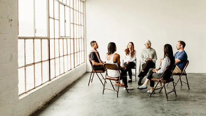 Group of adults meeting in a circle formation.