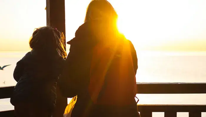Mother and child watching sunset.