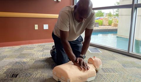 A person performing CPR on a torso