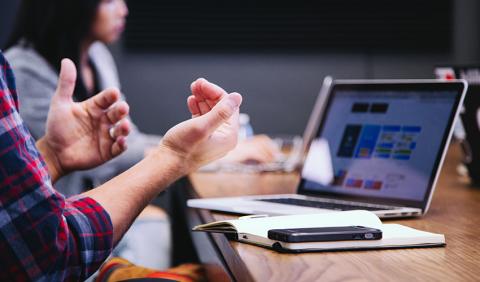 employees at meeting with computer and paper