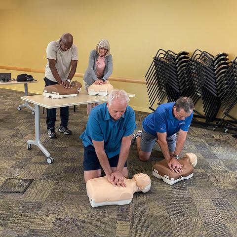 People practicing CPR in classroom.