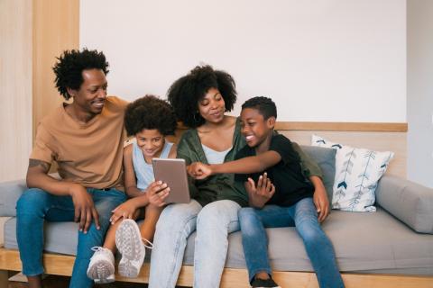 family sitting on couch playing a game